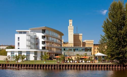 a building next to a body of water at Vienna House by Wyndham Havelufer Potsdam in Potsdam