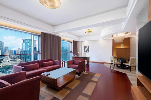 a living room with a couch and a table at Swissôtel Grand Shanghai - Stroll down West Nanjing Road and soak in downtown Shanghai vibrancy in Shanghai