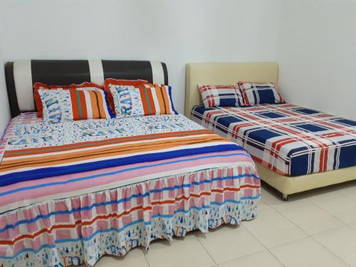 duas camas sentadas uma ao lado da outra num quarto em D'tasek Homestay Gua Musang em Gua Musang