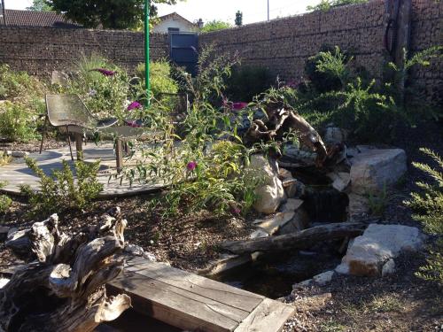 a garden with a bench and some flowers and a log at Aux Terrasses in Tournus