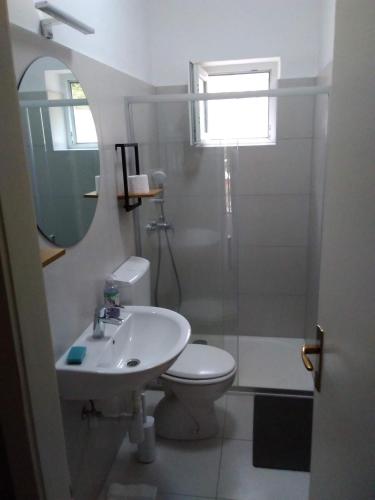 a bathroom with a sink and a toilet and a mirror at House " Bond " in Tisno