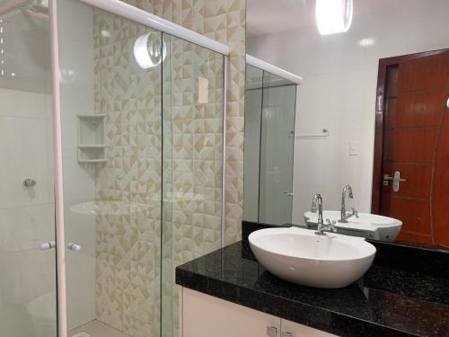 a bathroom with a sink and a glass shower at Casa de Praia Panaquatira - São J. Ribamar in São-José-do-Ribamar