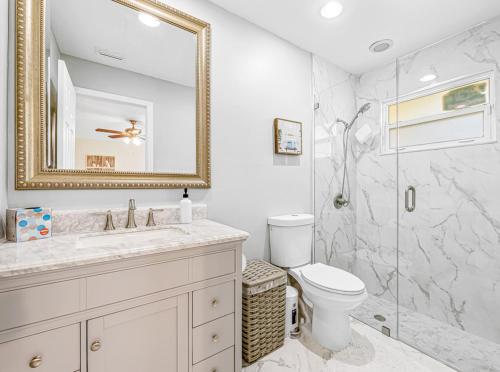 a bathroom with a shower and a toilet and a mirror at Beautiful Home Away From Home in Royal Palm Beach
