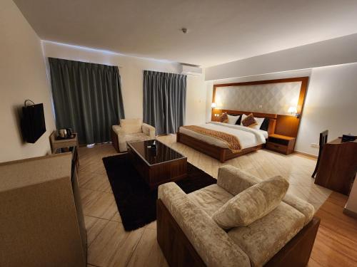 a hotel room with a bed and a couch at Aquavista Hotel & Suites in Aqaba