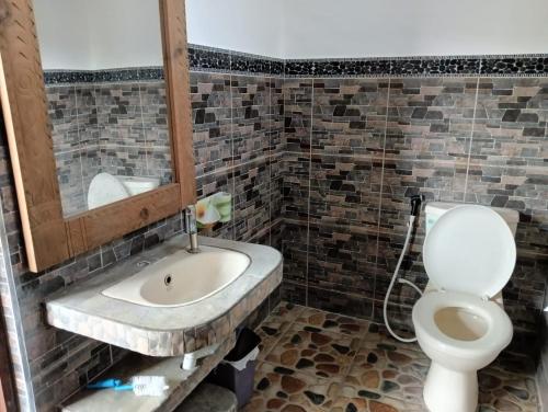 La salle de bains est pourvue de toilettes et d'un lavabo. dans l'établissement Lee Wong house 2, à Ubud