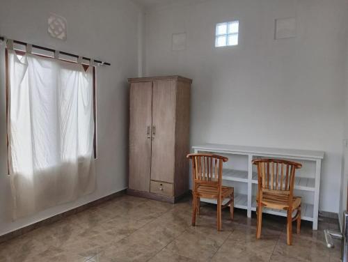 une chambre avec deux chaises, un bureau et une armoire dans l'établissement Lee Wong house 2, à Ubud
