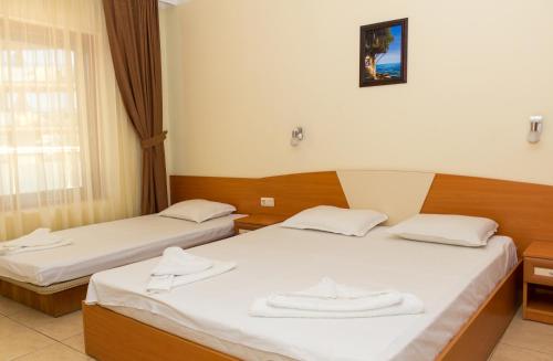 Dos camas en una habitación de hotel con toallas encima. en Hostel Malibu, en Sunny Beach