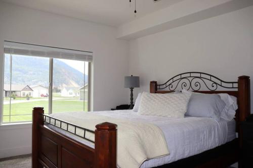 1 dormitorio con cama y ventana grande en Rustic Range Retreat - Glacier Park Getaway en Columbia Falls