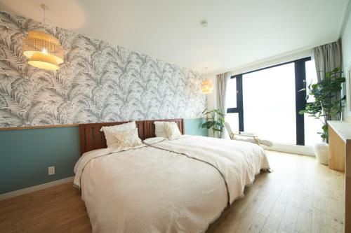 a bedroom with a large bed and a wall mural at Villacation the Loose in Minamiawaji
