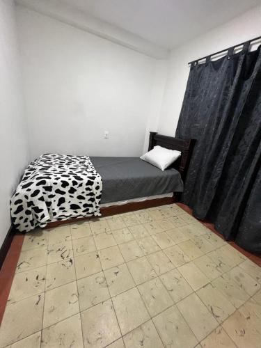 a room with a bed with a drapes and a bed sidx sidx sidx at La casa del tranvía in Medellín