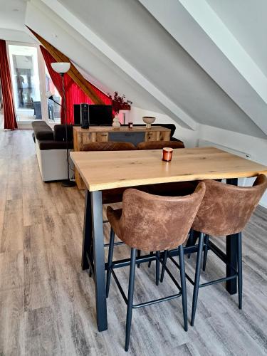 a wooden table with two chairs in a living room at Wohnen über den Dächern von Bregenz in Bregenz