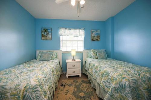 2 camas en una habitación con paredes azules en Welcome to the Pelican Lodge ! en Tavernier