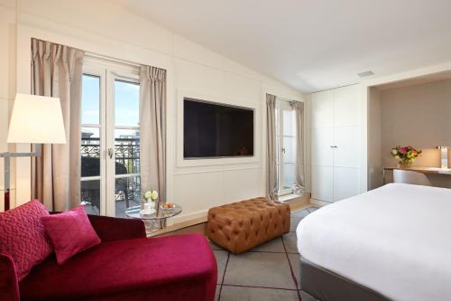 a bedroom with a bed and a couch and a tv at Hotel Opéra Richepanse in Paris