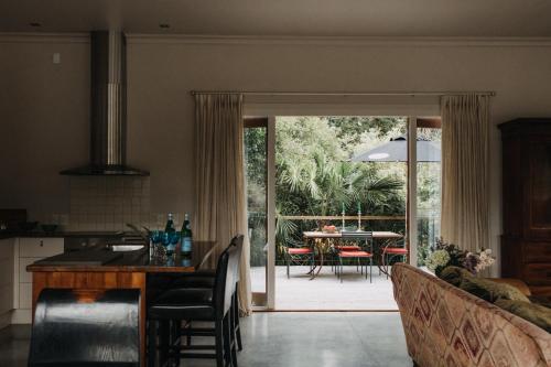 a kitchen and living room with a table and a dining room at Arapata in Havelock North
