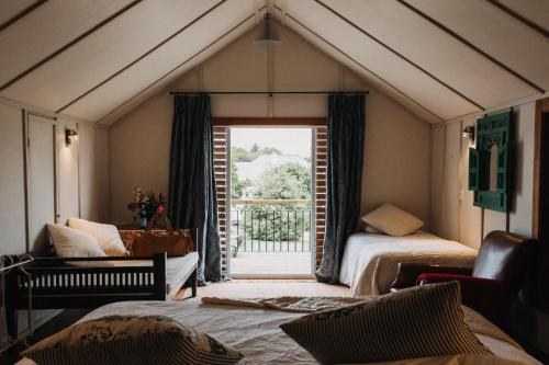 a attic room with two beds and a window at Arapata in Havelock North