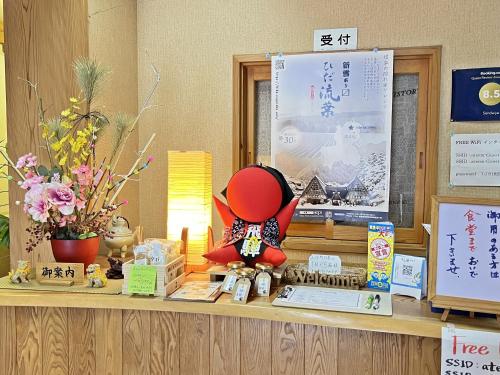 a counter with a red doll sitting on top of it at Sendaiya in Hida