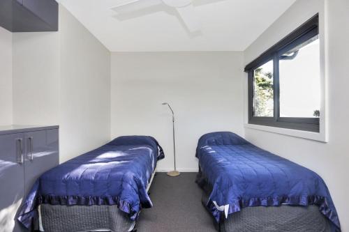 two beds in a room with a window at Architectural Design on the Beach in Winda Woppa