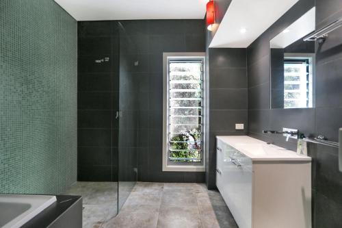 ein Bad mit einem Waschbecken, einer Badewanne und einem Fenster in der Unterkunft Architectural Design on the Beach in Winda Woppa