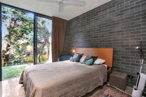 ein Schlafzimmer mit einem großen Bett mit Ziegelwand in der Unterkunft Architectural Design on the Beach in Winda Woppa