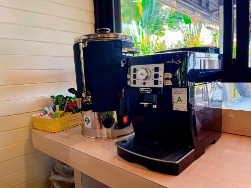 eine Kaffeemaschine auf einer Theke neben einem Fenster in der Unterkunft Baan Taranya Koh Yao Yai Resort in Ko Yao Yai