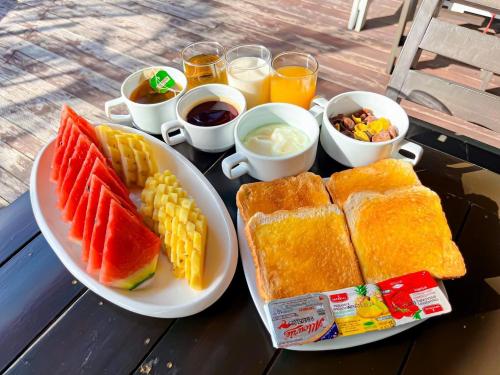 Ein Tisch mit zwei Tellern mit Sandwiches und Waffeln sowie Getränken in der Unterkunft Baan Taranya Koh Yao Yai Resort in Ko Yao Yai