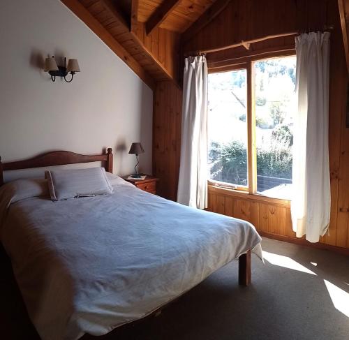 1 dormitorio con cama y ventana grande en Rudecindo Roca 1 en San Martín de los Andes