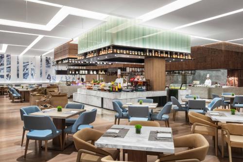 a rendering of a restaurant with tables and chairs at Hangzhou Marriott Hotel Lin'an in Lin'an