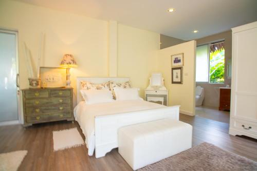 VillaMilla deluxe en-suite room في ماي هاد: غرفة نوم بسرير ابيض وخزانة ونافذة