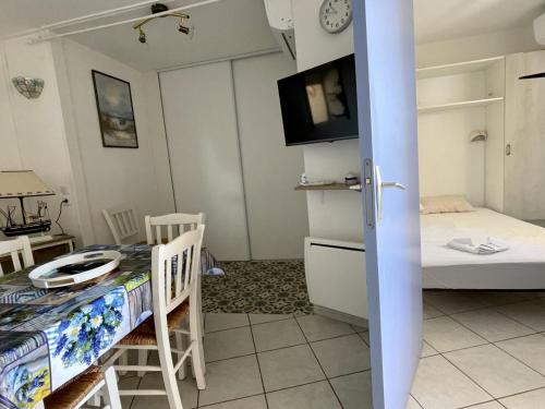 Cette chambre comprend une table à manger, un lit et une cuisine. dans l'établissement Appartement 2 pièces avec piscine proche commerces - FR-1-748-4, à Canet