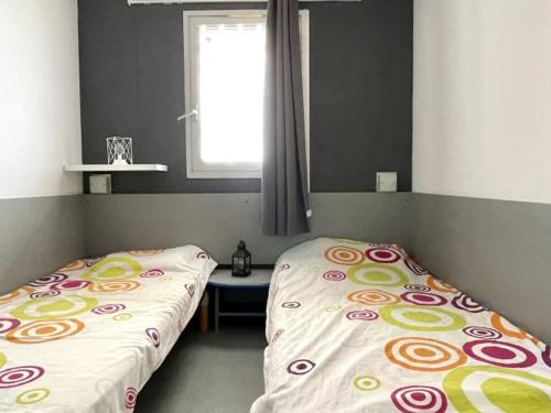 une chambre avec deux lits jumeaux et une fenêtre dans l'établissement Appartement avec Piscine et Terrasse Proche Commerces - FR-1-748-15, à Canet