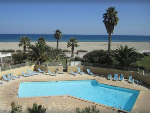 une grande piscine avec des chaises et une plage dans l'établissement Appartement avec Piscine et Terrasse Proche Commerces - FR-1-748-15, à Canet