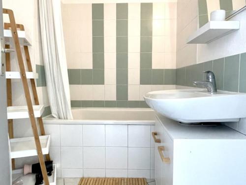 une salle de bain avec un lavabo et une baignoire dans l'établissement Appartement rénové avec piscine commune, 4 couchages, climatisé, wifi, terrasse vue mer - FR-1-748-3, à Canet