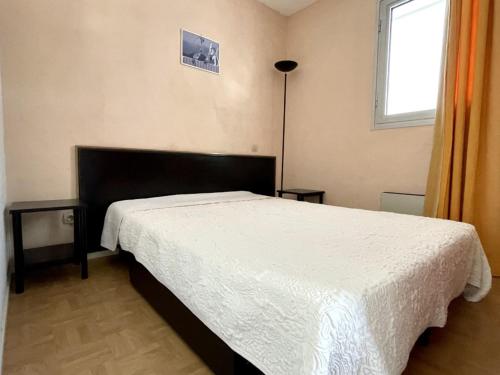 - une chambre avec un lit doté d'un couvre-lit blanc et d'une fenêtre dans l'établissement Appartement 2 pièces avec parking, WIFI, et climatisation - FR-1-748-14, à Canet