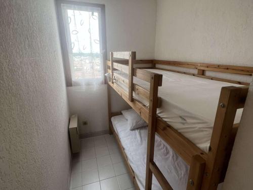 une chambre avec deux lits superposés et une fenêtre dans l'établissement T3 pour 4 pers. à 50m de la plage, parking privatif - FR-1-701-71, à Valras-Plage