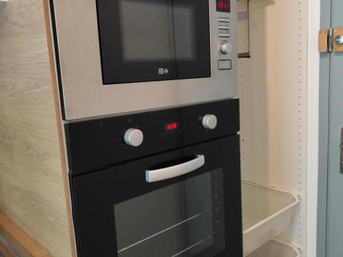 a microwave sitting on top of a oven at Studio Villard-de-Lans, 1 pièce, 4 personnes - FR-1-689-124 in Villard-de-Lans