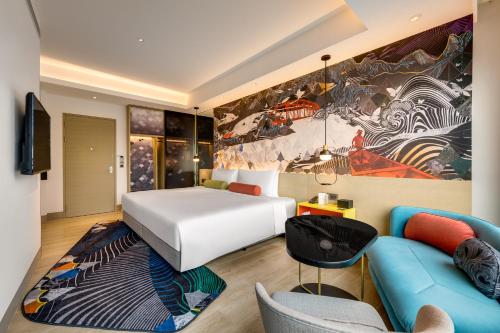 a hotel room with a bed and a couch at Hotel Indigo Taipei North by IHG in Taipei