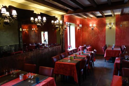a dining room with red tables and chairs at Le Fauverney Lodge in Fauverney