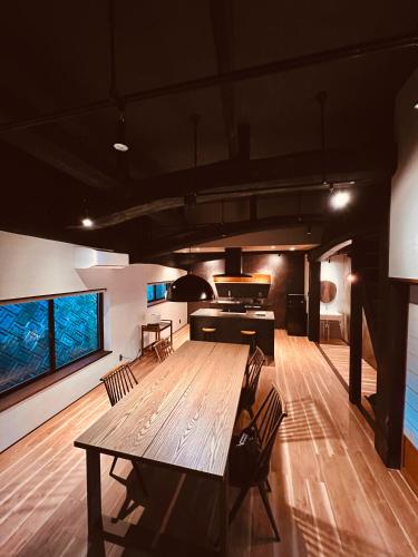 a large dining room with a wooden table and chairs at Kuon 一棟貸し(素泊まり)北欧サウナ＋ガーデン付き古民家 in Kisa