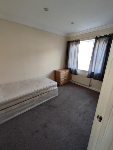 an empty room with a bed and a window at Apartment in London in London