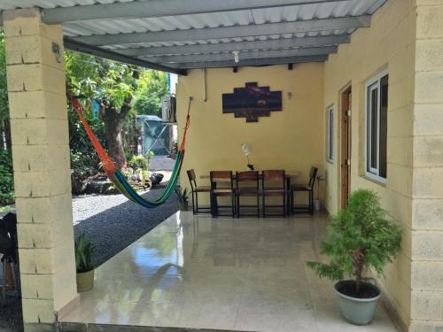 a porch of a house with a patio with a table at Hostal Camila’s in Tamanique
