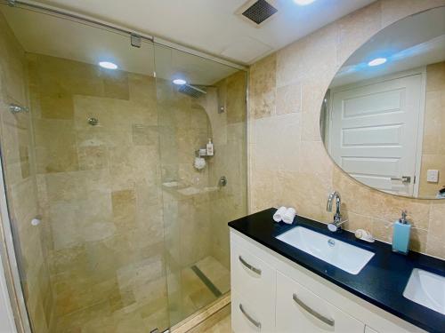 a bathroom with a shower and a sink and a mirror at Charming Burleigh Studio in Gold Coast