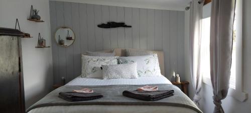 1 dormitorio con 1 cama con 2 toallas en The Artists Cottage - absolute waterfront, en Strahan