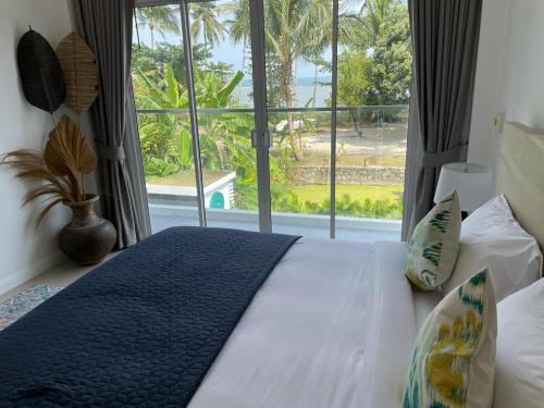 a bedroom with a bed with a large window at BALANCE BEACH VILLA in Koh Samui 