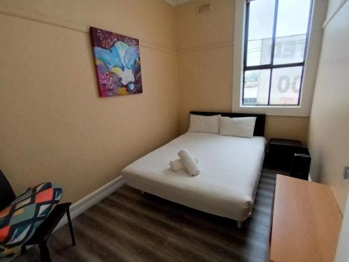 a bedroom with a white bed and a window at Albion Motel Finley in Finley