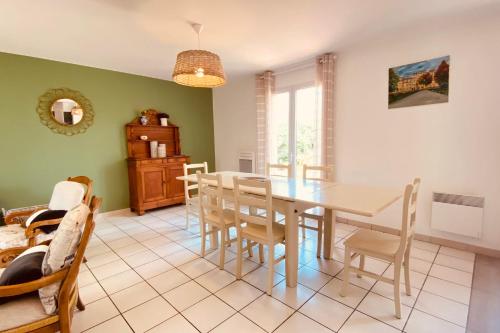 ein Esszimmer mit einem Tisch und Stühlen in der Unterkunft Cozy house with garden in La Teste-de-Buch in La Teste-de-Buch