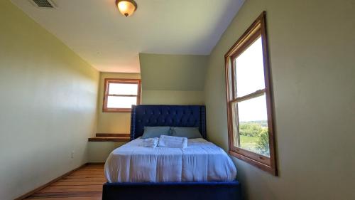 a bedroom with a blue bed and a window at Modern Log House First Level Primary in Winchester