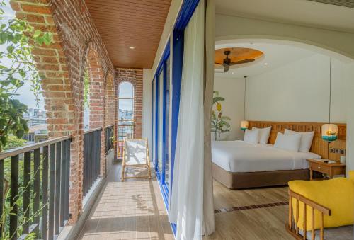 a bedroom with a bed and a balcony at Seahorse Signature Danang Hotel by Haviland in Da Nang