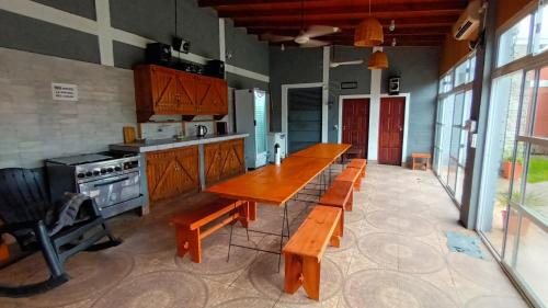 a kitchen with a long wooden table and benches at Casa Quinta Los Amigos in Corrientes