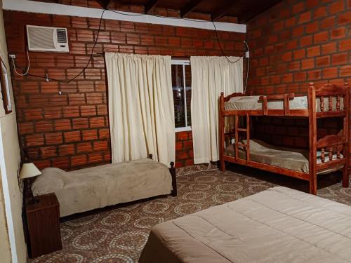 a bedroom with two bunk beds and a brick wall at Casa Quinta Los Amigos in Corrientes