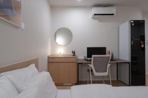 a bedroom with a bed and a desk with a computer at The Hyoosik Aank Hotel Ilsan Tanhyeon in Goyang